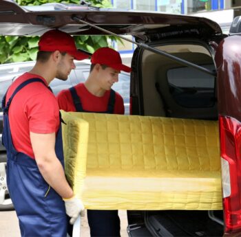 Günstig umziehen in Worms: Umzugshelfer laden ein gelbes Sofa in einen Transporter