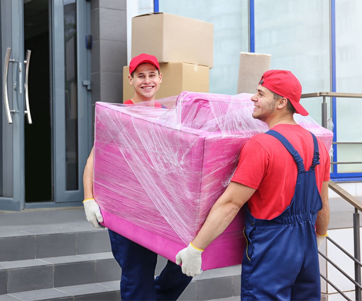 Umzugsunternehmen Worms: Zwei Umzugshelfer tragen ein in Folie gepacktes Möbelstück für den Umzug nach Moldau