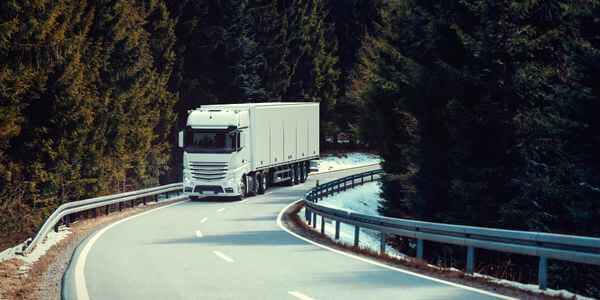 Klaviertransport Worms: Lkw fährt auf einer kurvigen Straße durch den Wald
