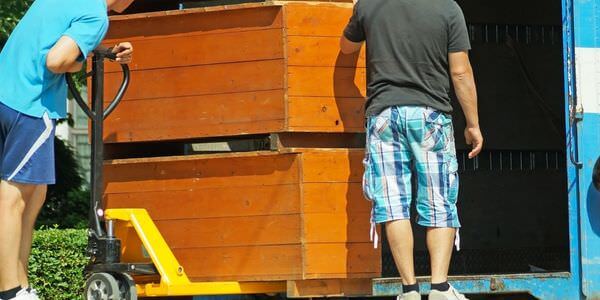 Möbellift Worms: Zwei Helfer tragen einen Holzschrank aus einem Lkw