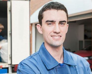 Umzugshelfer Worms Lächelnder Umzugshelfer vor einem Transporter – Umzugshelfer Worms
