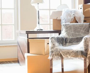Umzugskartons Worms Kartons zwischen Sesseln in einem hellen Zimmer – Umzugskartons Worms